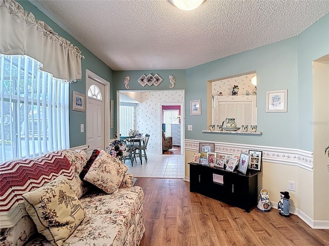 living area featuring baseboards, a textured ceiling, and wood finished floors