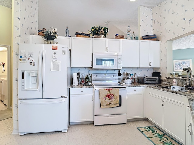 kitchen featuring a sink, a textured ceiling, white appliances, wallpapered walls, and white cabinets