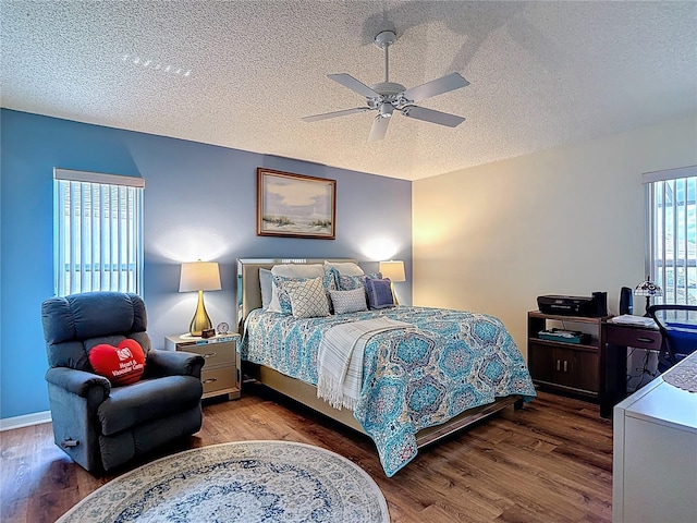 bedroom with baseboards, a textured ceiling, wood finished floors, and ceiling fan
