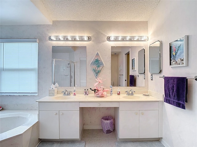 full bathroom featuring a stall shower, double vanity, a sink, and a garden tub