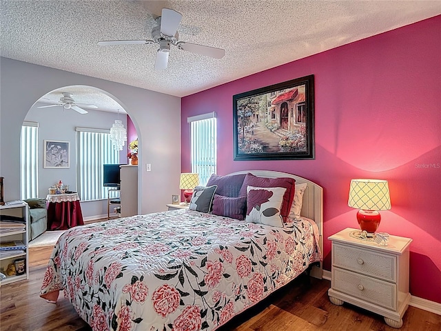 bedroom with multiple windows, wood finished floors, and a textured ceiling