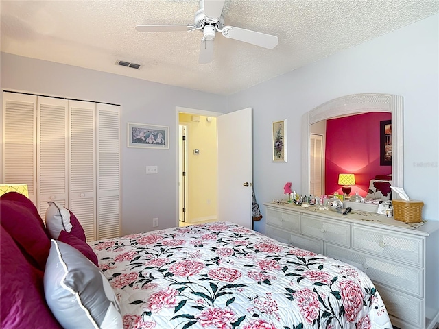 bedroom featuring a ceiling fan, visible vents, a closet, and a textured ceiling