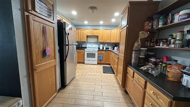 kitchen with white electric range oven, freestanding refrigerator, dark countertops, and recessed lighting