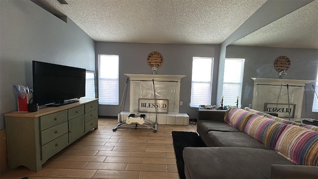 living room featuring a textured ceiling, a premium fireplace, plenty of natural light, and wood finished floors