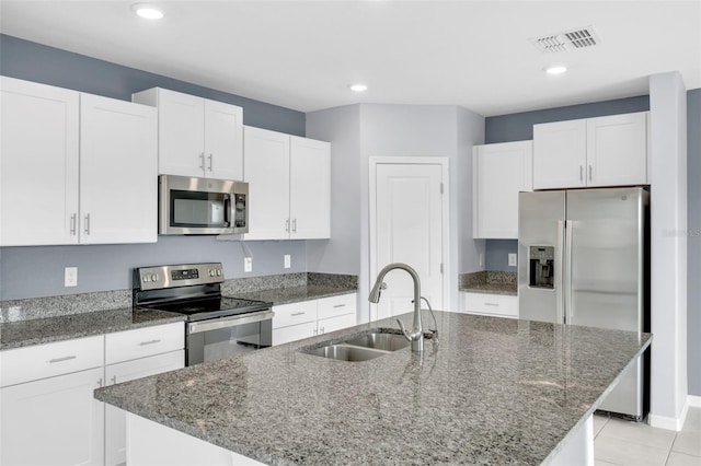 582 Royal Empress Dr, Ruskin, FL 33570 - kitchen featuring appliances with stainless steel finishes, white cabinetry, an island with sink, dark stone countertops, and recessed lighting