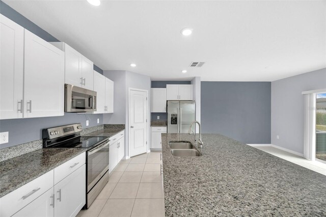 582 Royal Empress Dr, Ruskin, FL 33570 - kitchen with appliances with stainless steel finishes, white cabinetry, stone countertops, light tile patterned flooring, and recessed lighting