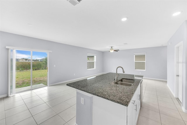 582 Royal Empress Dr, Ruskin, FL 33570 - kitchen featuring light tile patterned floors, a ceiling fan, dark stone counters, open floor plan, and a kitchen island with sink