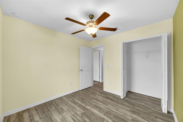 582 Royal Empress Dr, Ruskin, FL 33570 - unfurnished bedroom with wood finished floors, a closet, and a ceiling fan