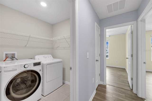 582 Royal Empress Dr, Ruskin, FL 33570 - laundry room featuring washing machine and dryer and light wood-style flooring