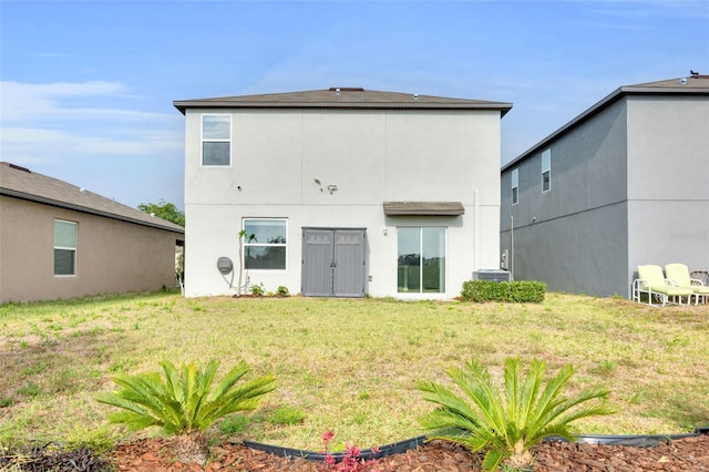 582 Royal Empress Dr, Ruskin, FL 33570 - back of house featuring a lawn and stucco siding