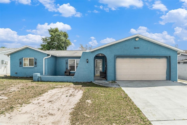 ranch-style house with a garage, driveway, stucco siding, and a front lawn