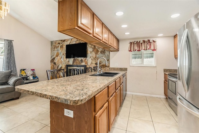 kitchen featuring light tile patterned floors, a sink, open floor plan, light countertops, and appliances with stainless steel finishes