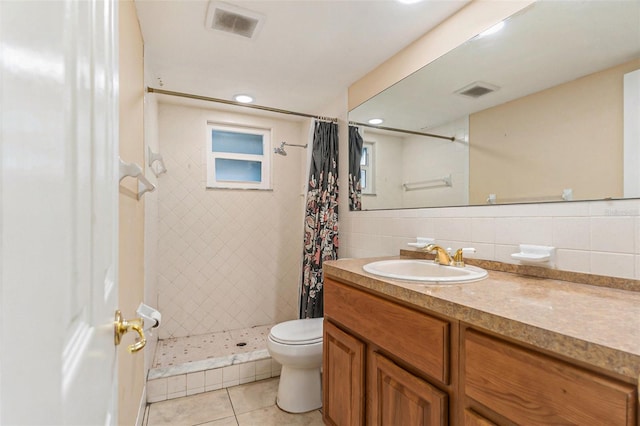 bathroom featuring vanity, tile patterned flooring, toilet, tile walls, and a stall shower