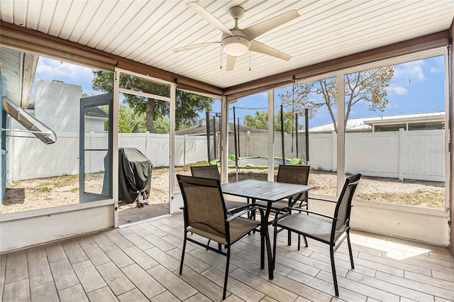 sunroom / solarium featuring outdoor dining space and a ceiling fan
