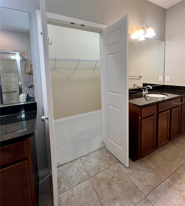 5221 Bannister Park Ln, Lithia, FL 33547 - bathroom featuring vanity, tile patterned floors, tiled shower, and a spacious closet