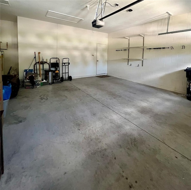 5221 Bannister Park Ln, Lithia, FL 33547 - garage featuring concrete block wall, a garage door opener, and visible vents