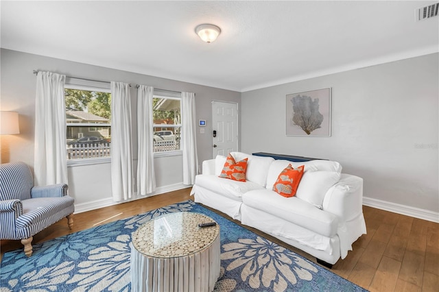 living area featuring wood finished floors, baseboards, and visible vents