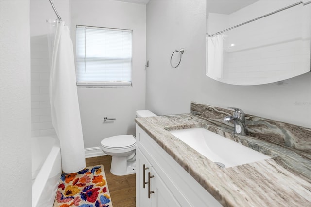 bathroom featuring toilet, wood finished floors, vanity, and shower / bathtub combination with curtain