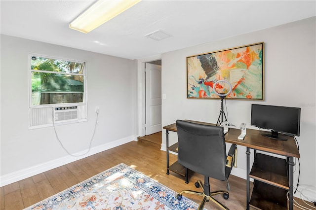 office space featuring visible vents, baseboards, cooling unit, and wood finished floors