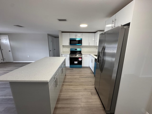 kitchen featuring visible vents, light wood-type flooring, appliances with stainless steel finishes, and a center island