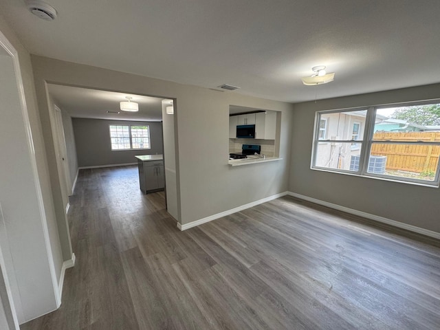 interior space featuring baseboards, dark wood-style floors, and visible vents