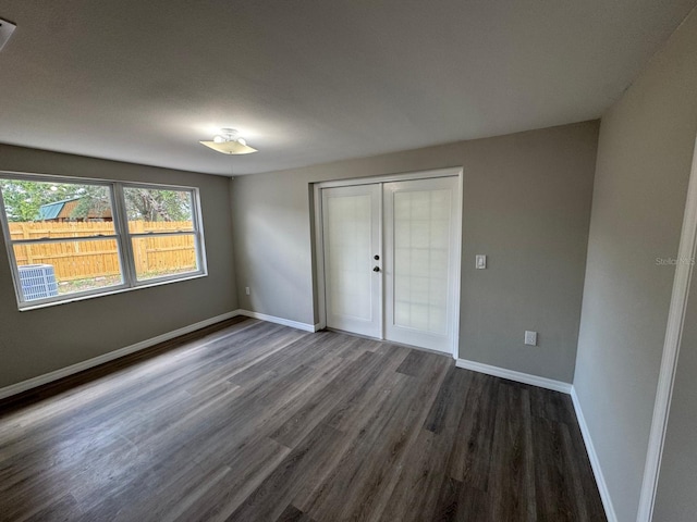 interior space featuring dark wood-type flooring and baseboards