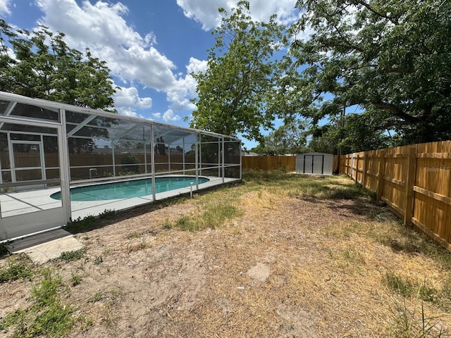 view of pool with a shed, a fenced backyard, a fenced in pool, a lanai, and an outdoor structure