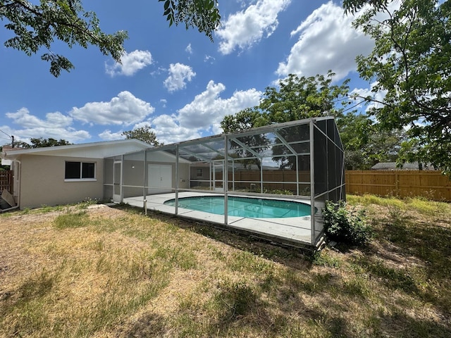 view of swimming pool featuring fence, a fenced in pool, a yard, and a lanai