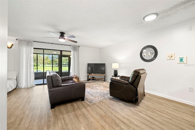13512 Palmwood Ln Unit 13512, Tampa, FL 33618 - living room featuring baseboards, light wood-type flooring, a textured ceiling, and ceiling fan