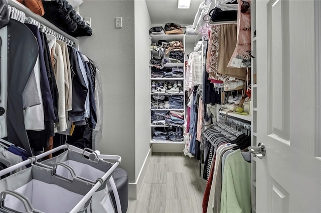 walk in closet with wood finished floors