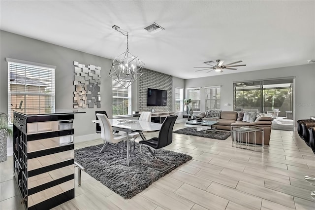 dining space with ceiling fan with notable chandelier, baseboards, and visible vents