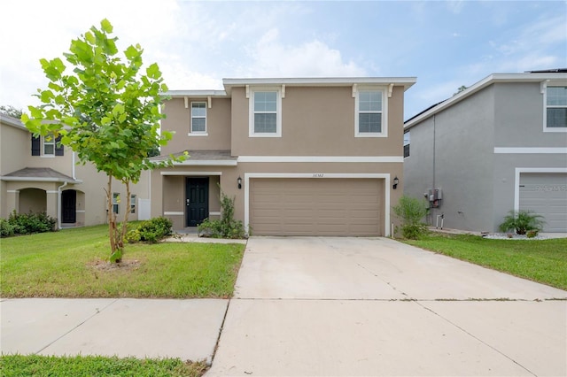 traditional-style house with an attached garage, driveway, stucco siding, and a front lawn