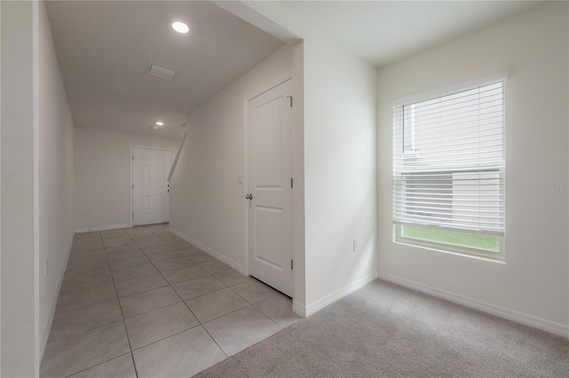 corridor featuring light tile patterned floors, baseboards, visible vents, recessed lighting, and light carpet