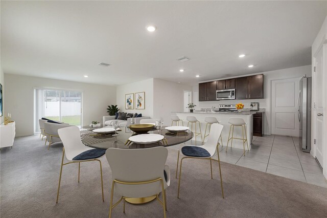 dining space with light tile patterned floors, recessed lighting, visible vents, and light carpet