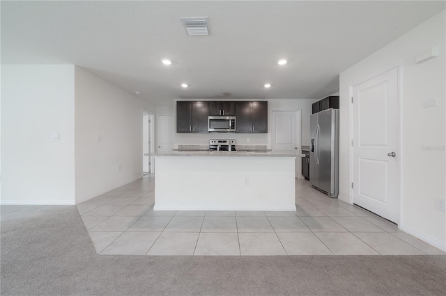 kitchen featuring light tile patterned floors, light colored carpet, visible vents, and stainless steel appliances