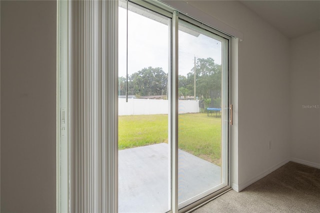 doorway with baseboards and light colored carpet