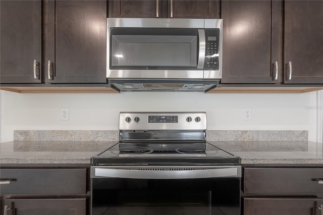 kitchen with dark brown cabinetry, light stone countertops, and stainless steel appliances