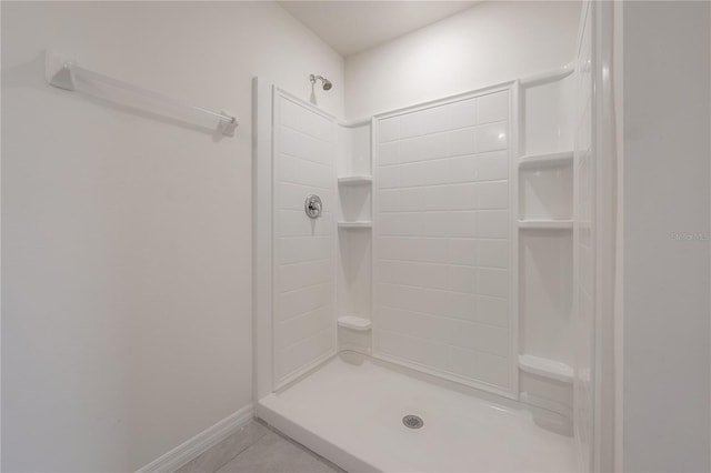 full bath with a shower stall, tile patterned floors, and baseboards