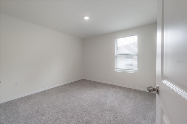 empty room featuring carpet floors, baseboards, and recessed lighting