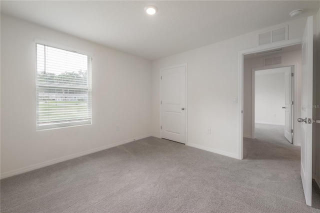 spare room with baseboards, carpet, and visible vents