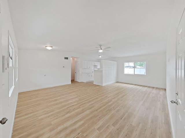 5772 4th Ave N, Saint Petersburg, FL 33710 - unfurnished living room with light wood-style floors, baseboards, a ceiling fan, and visible vents