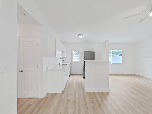 5772 4th Ave N, Saint Petersburg, FL 33710 - kitchen featuring a sink, freestanding refrigerator, light countertops, and light wood-type flooring