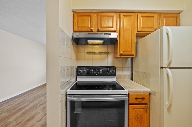 2366 Shelley St Unit 7, Clearwater, FL 33765 - kitchen featuring freestanding refrigerator, light countertops, electric range oven, under cabinet range hood, and brown cabinets