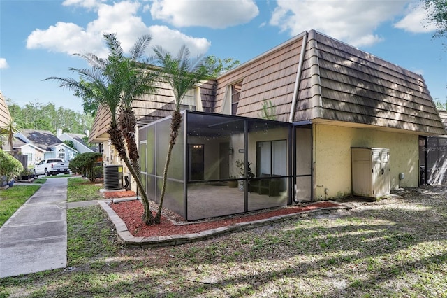 12736 Wood Trail Blvd, Tampa, FL 33625 - rear view of property featuring central AC unit, stucco siding, and mansard roof