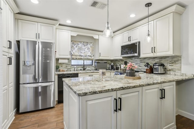12736 Wood Trail Blvd, Tampa, FL 33625 - kitchen featuring visible vents, a peninsula, light wood-style floors, white cabinetry, and stainless steel appliances