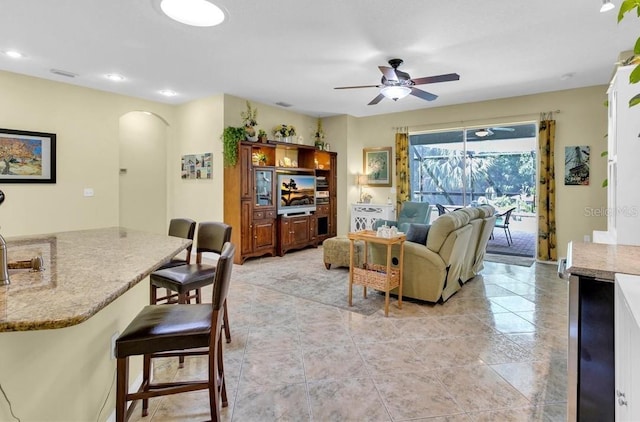 8202 Pinewood Run Ct, Tampa, FL 33647 - living room featuring arched walkways, ceiling fan, recessed lighting, and light tile patterned floors