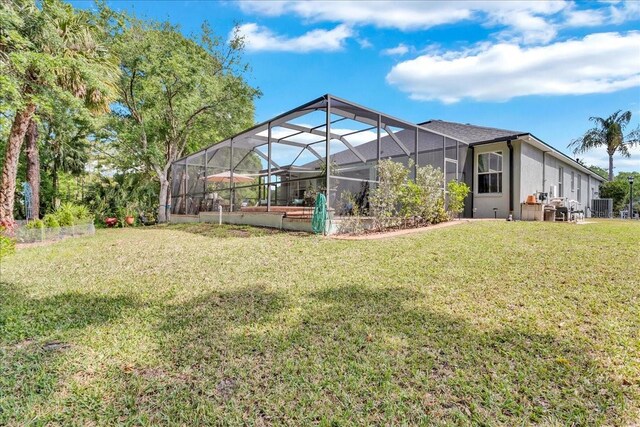 8202 Pinewood Run Ct, Tampa, FL 33647 - rear view of house featuring a yard, glass enclosure, cooling unit, and stucco siding