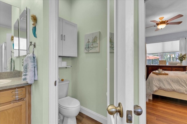 8202 Pinewood Run Ct, Tampa, FL 33647 - bathroom with vanity, ensuite bathroom, toilet, wood finished floors, and a ceiling fan