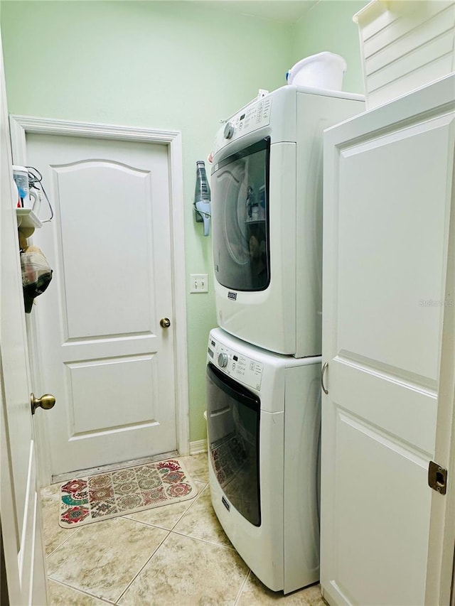 8202 Pinewood Run Ct, Tampa, FL 33647 - laundry area featuring stacked washing machine and dryer, light tile patterned floors, and baseboards