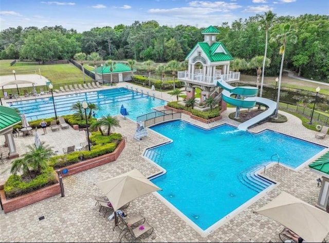 8202 Pinewood Run Ct, Tampa, FL 33647 - community pool with a water slide, view of wooded area, and a patio